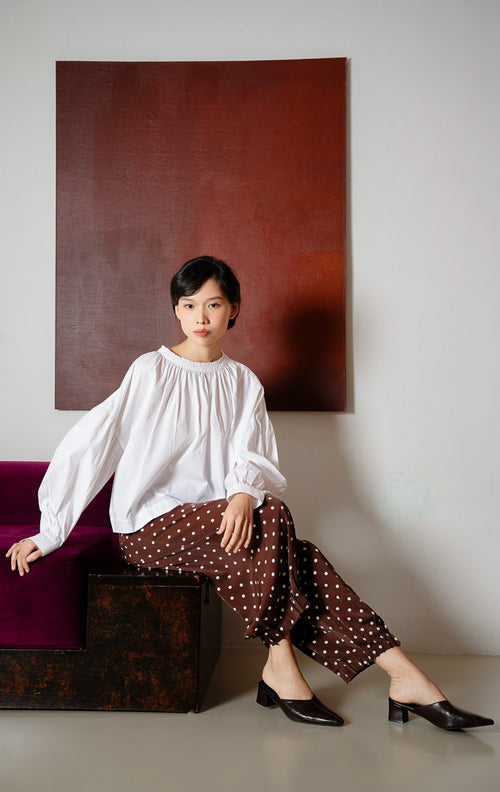 Atasan blouse wanita warna putih Morgana Top berbahan katun breathable dengan aksen kancing unik pada bagian bahu untuk gaya clean dan office look.