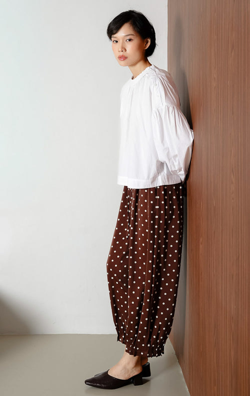 Atasan blouse wanita warna putih Morgana Top berbahan katun breathable dengan aksen kancing unik pada bagian bahu untuk gaya clean dan office look.