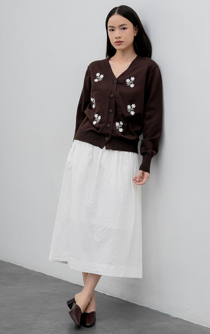Kardigan rajut wanita lengan panjang warna cokelat tua (dark brown) Morlith Cardigan dengan kerah V (V-neck), bukaan kancing depan, dan aksen bordir bunga (floral embroidery).