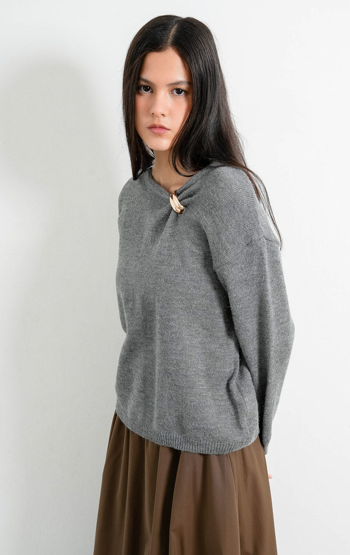 Sweter wanita lengan panjang warna abu-abu (grey) Morvia Sweater berbahan rajut halus (fine-gauge knit) dengan kerah bulat (round neckline), aksen cincin emas di bahu (gold-tone ring detail), dan ujung rajut elastis (ribbed trims). 

