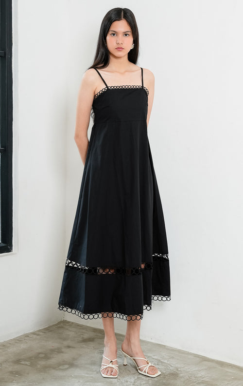 Dress wanita model A-line warna hitam (black A-line dress) Nicolle Dress dengan detail hiasan lingkar benang (loop trim detailing) di bagian garis leher, tali bahu spaghetti yang dapat disesuaikan (adjustable spaghetti straps), serta siluet ringan bertekstur. 
