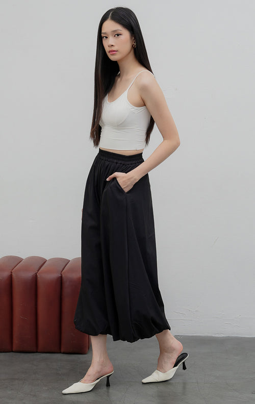 Celana panjang wanita model baloon (balloon-leg pants) warna hitam (black) Nikolai Pants berbahan campuran katun nilon dengan detail kerut ujung celana (gathered hem) dan pinggang karet.
