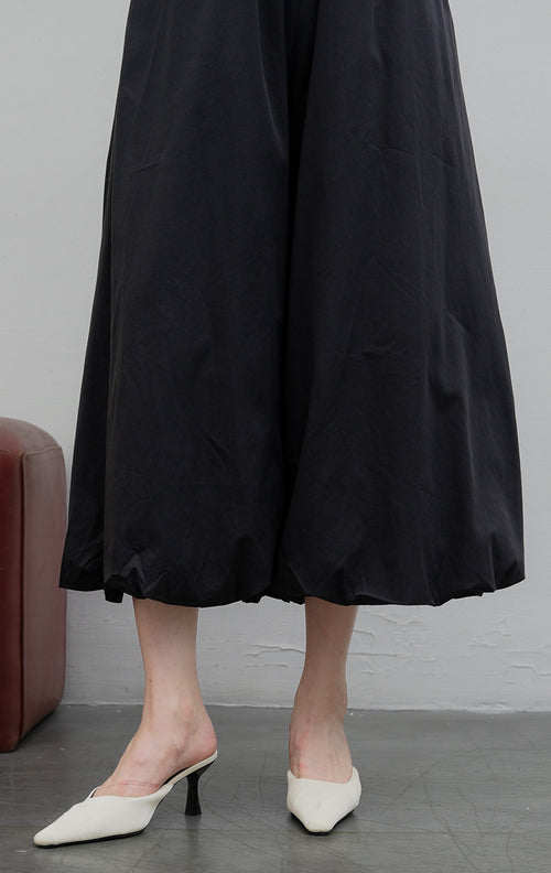 Celana panjang wanita model baloon (balloon-leg pants) warna hitam (black) Nikolai Pants berbahan campuran katun nilon dengan detail kerut ujung celana (gathered hem) dan pinggang karet. 