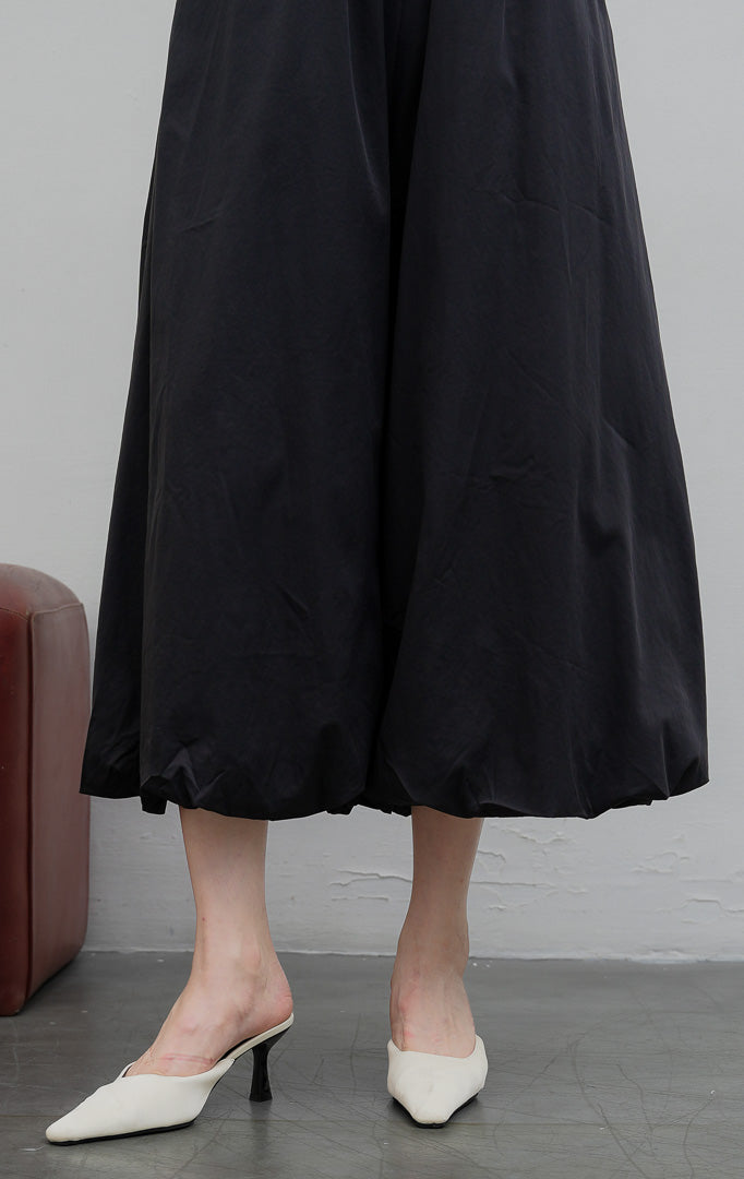 Celana panjang wanita model baloon (balloon-leg pants) warna hitam (black) Nikolai Pants berbahan campuran katun nilon dengan detail kerut ujung celana (gathered hem) dan pinggang karet. 