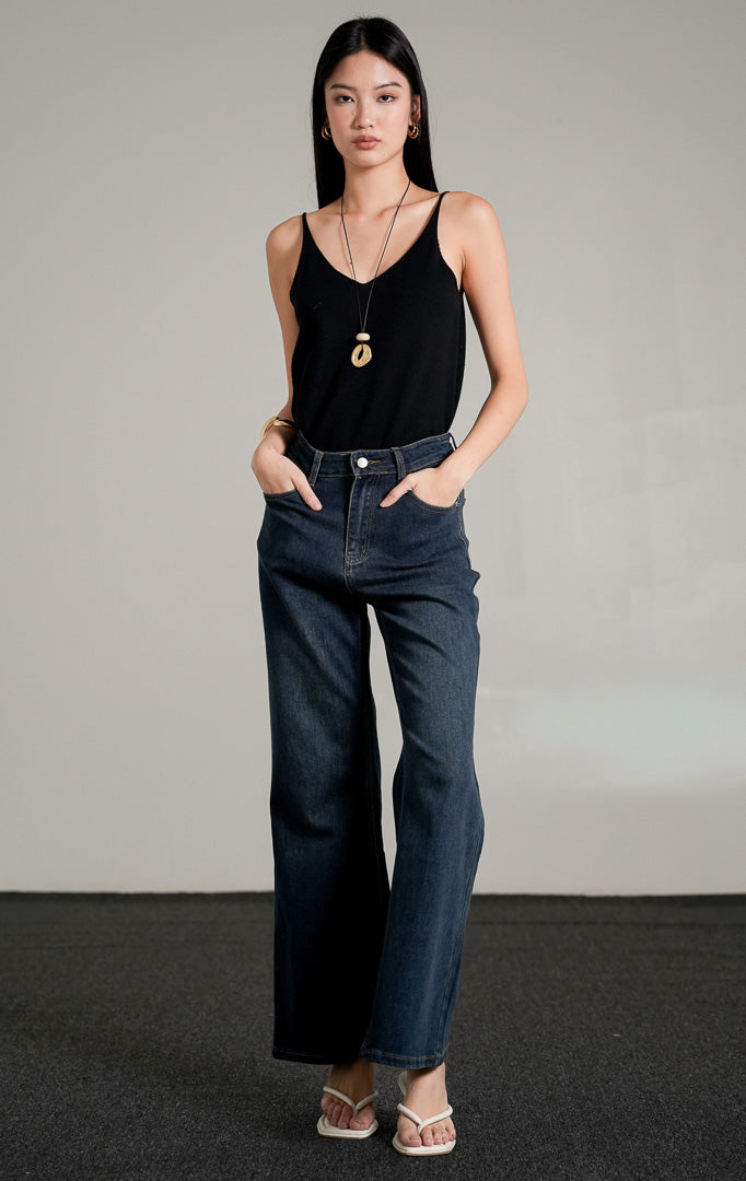 Oceanne Jeans, celana jeans biru tua (dark denim) dengan potongan lurus (straight leg) dan pinggang tinggi, dipadukan dengan tank top hitam.