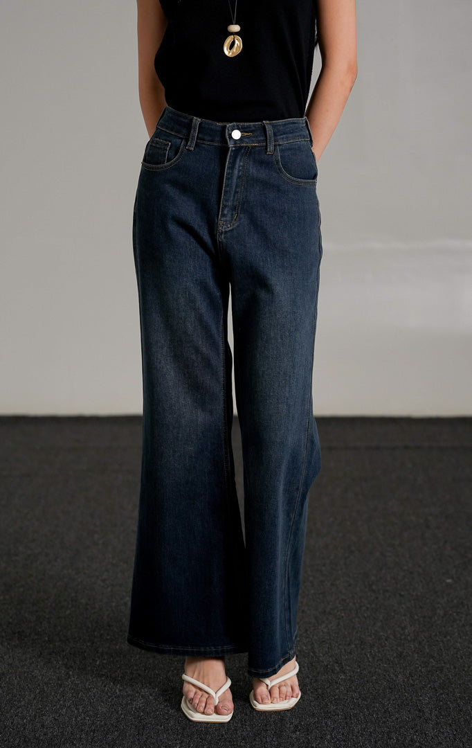 Oceanne Jeans, celana jeans biru tua (dark denim) dengan potongan lurus (straight leg) dan pinggang tinggi, dipadukan dengan tank top hitam.