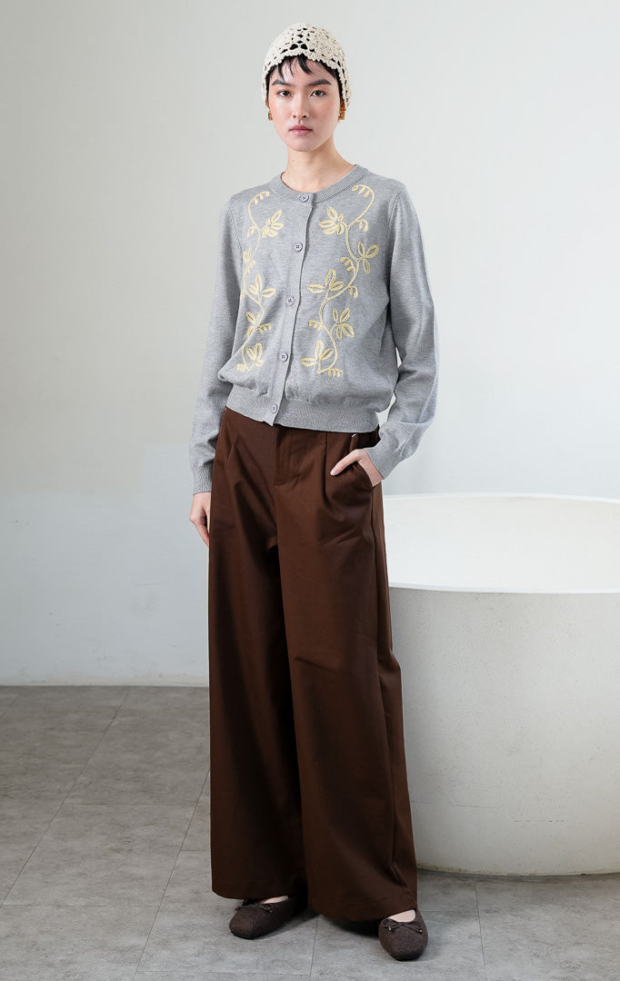 Kardigan rajut wanita lengan panjang warna abu-abu (grey) Oriana Cardigan berbahan soft knit dengan kerah bulat (rounded neckline), bukaan kancing depan, dan bordir motif sulur bunga warna kontras (contrasting floral vine embroidery). 

