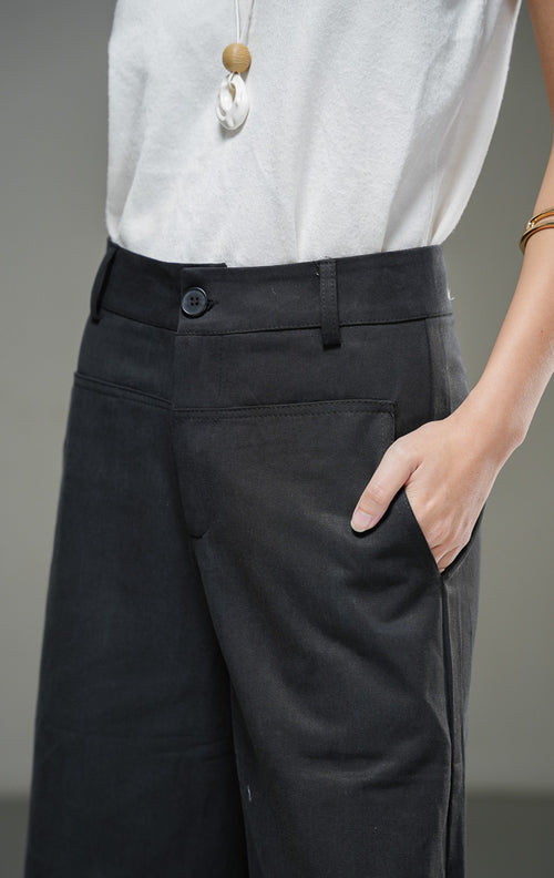 Celana kulot wanita Paladia Pants warna hitam berbahan cotton twill terstruktur dengan potongan wide-leg, saku samping fungsional, dan penutup kancing depan. 