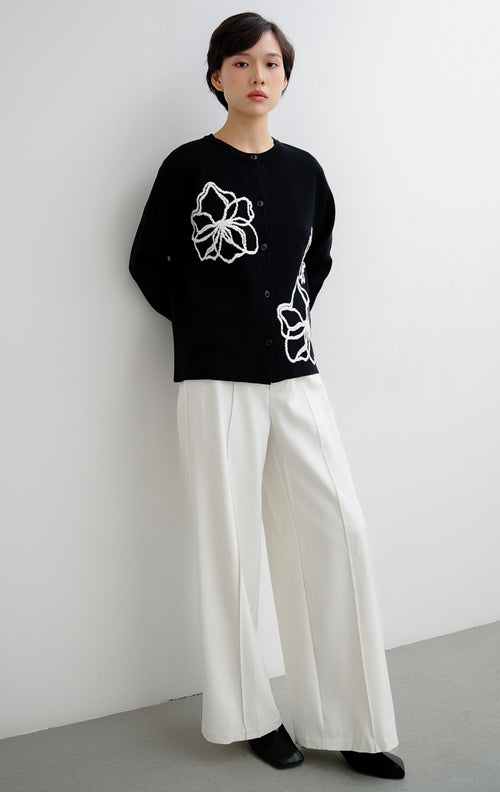 Cardigan rajut wanita warna hitam Peppie Cardigan berbahan soft stretch dengan detail bordir bunga (flower embroidery) dan kancing depan (button-up).