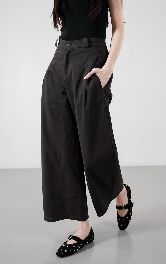 Detail depan Regina Pants warna dark grey, celana panjang dengan detail jahitan panel melengkung yang unik, saku samping, dan potongan lebar.