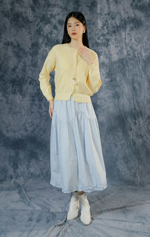 Cardigan lengan panjang wanita Rivere warna kuning mentega (butter yellow) berbahan rajut premium dengan detail dua kancing depan bergaya mutiara. 

