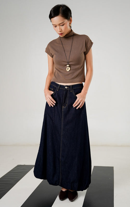 Rok denim panjang wanita Rouje Skirt Dark Blue dengan siluet balloon, detail jahitan vertikal di tengah, dan karet pinggang belakang yang nyaman. 