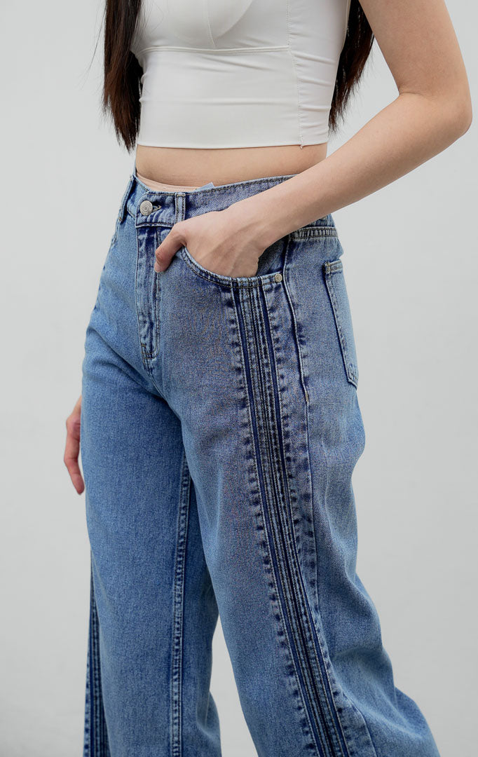 Celana jeans wanita model lurus (straight leg) warna biru muda (light denim) Rovex Pants dengan aksen jahitan lipit samping (pintuck detailing), saku fungsional, dan pinggang karet belakang.