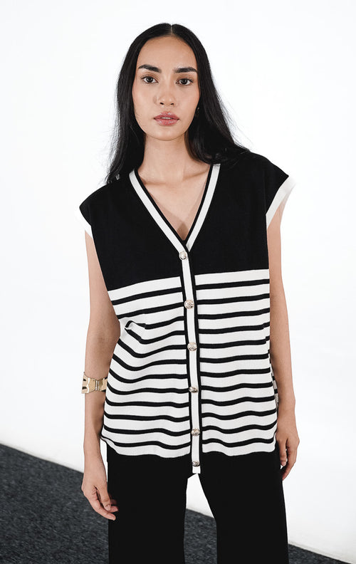 Rucci Set warna hitam, setelan rajut yang terdiri dari rompi v-neck motif garis putih dengan kancing emas dan celana panjang hitam.1