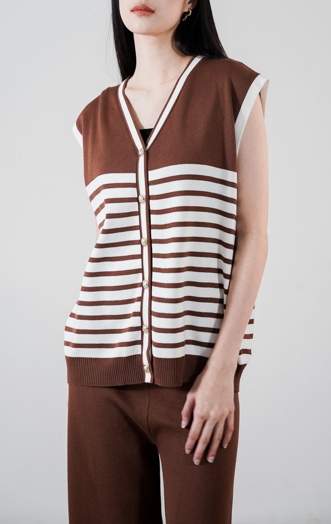 Rucci Set warna cokelat, setelan rajut yang terdiri dari rompi v-neck motif garis dengan kancing emas dan celana panjang senada.

