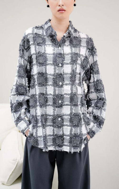 Kemeja wanita lengan panjang motif kotak-kotak (plaid) warna hitam Selene Top dengan kancing depan dan aksen rumbai (fringed detailing). 