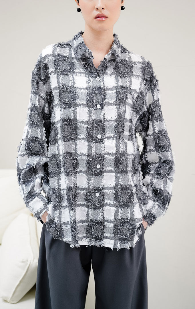Kemeja wanita lengan panjang motif kotak-kotak (plaid) warna hitam Selene Top dengan kancing depan dan aksen rumbai (fringed detailing). 