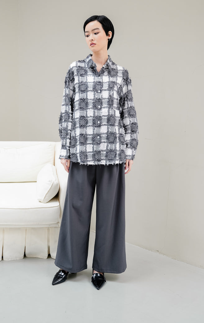 Kemeja wanita lengan panjang motif kotak-kotak (plaid) warna hitam Selene Top dengan kancing depan dan aksen rumbai (fringed detailing). 