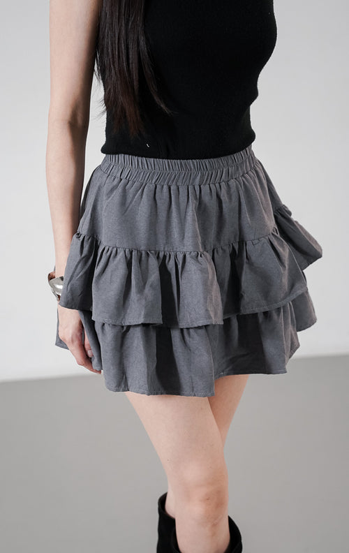 Detail dekat Seloria Skort warna abu-abu (grey) dengan siluet rok mini bertingkat (tiered ruffle) dan pinggang karet elastis.1