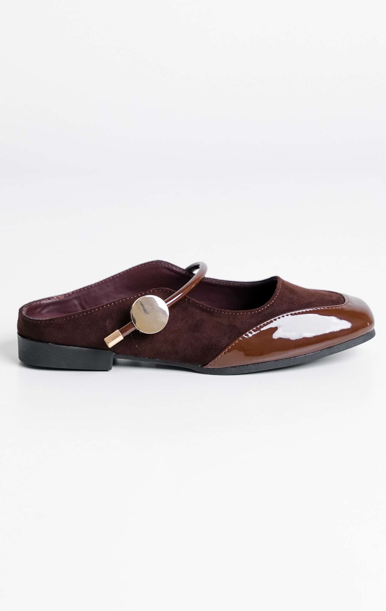 Tampilan flat lay sepasang Maisie Flats warna dark brown, sepatu mules flat selop wanita model Mary Jane bahan suede cokelat tua maroon dengan cap depan kulit kilap patent leather dan kancing emas dari This Is April.