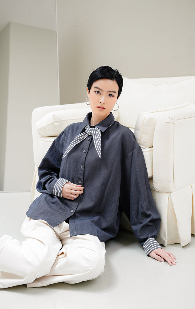 Kemeja lengan panjang wanita Serafia Top warna dark grey (abu-abu tua) berbahan katun dengan aksen syal motif garis (stripe scarf) di bagian kerah klasik. 