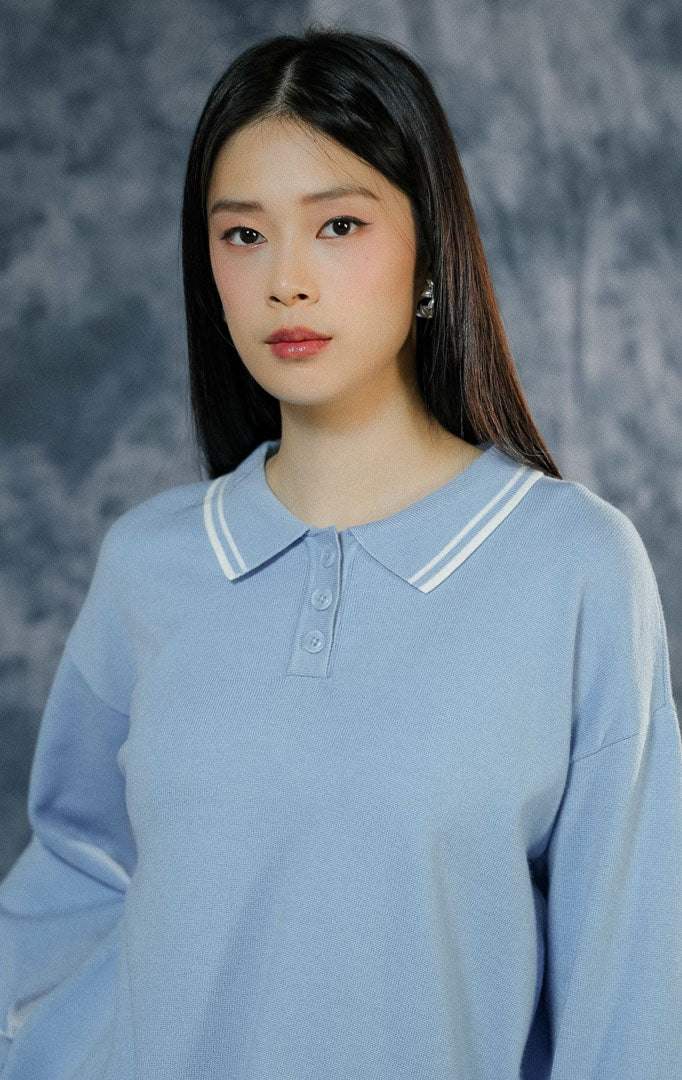 Atasan baju rajut wanita Sinclair warna biru muda (light blue) lengan panjang berkerah polo dengan paduan list garis putih dan keliman ruffle yang manis. 

