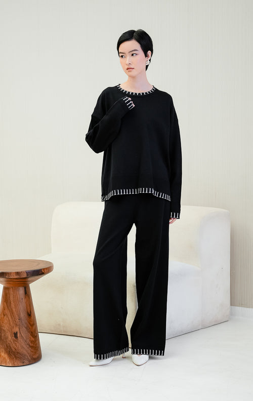 One set pakaian wanita Soobin Set warna hitam berbahan rajut (knit) halus, terdiri dari atasan lengan panjang dan celana panjang dengan aksen motif garis list putih di bagian hem/pinggiran. 