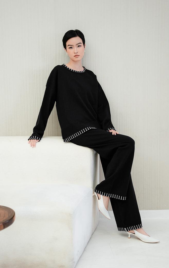 One set pakaian wanita Soobin Set warna hitam berbahan rajut (knit) halus, terdiri dari atasan lengan panjang dan celana panjang dengan aksen motif garis list putih di bagian hem/pinggiran. 