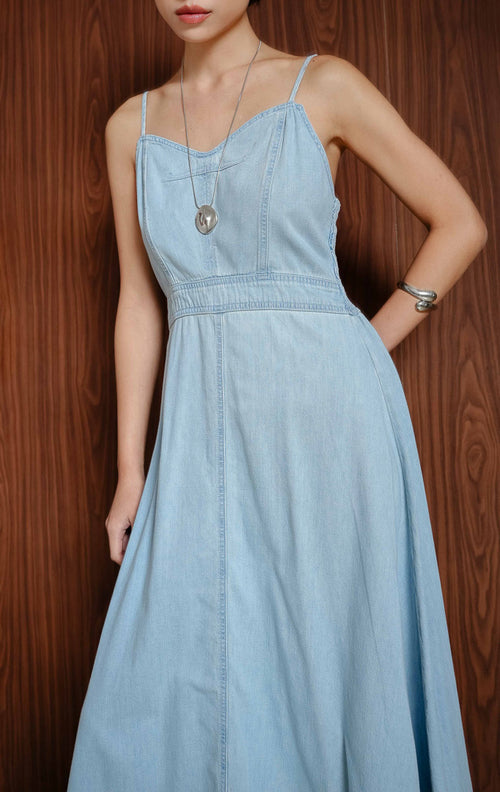 Maxi dress wanita berbahan denim warna biru muda (light denim) Sorelle Dress dengan siluet flowy dan tali bahu yang bisa disesuaikan (adjustable straps).
