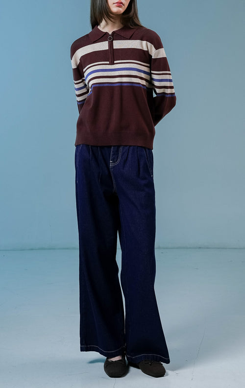 Model wanita mengenakan Bennet Striped Collared Sweater warna coklat, sweater rajut lengan panjang yang nyaman dengan motif garis horizontal dan kerah half-zip. 