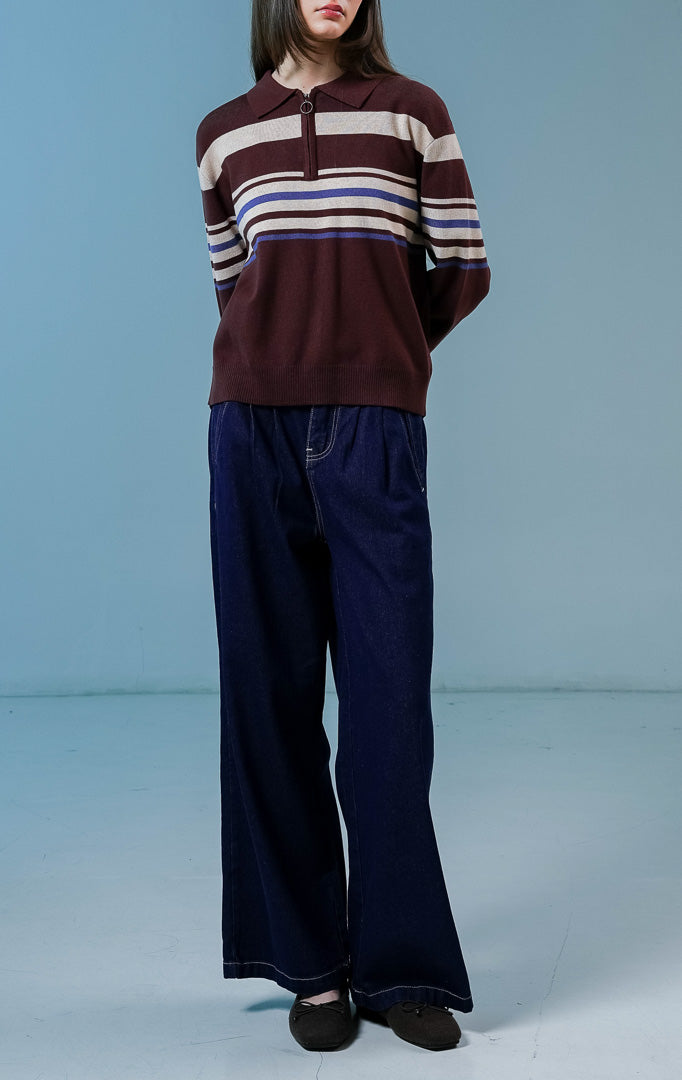 Model wanita mengenakan Bennet Striped Collared Sweater warna coklat, sweater rajut lengan panjang yang nyaman dengan motif garis horizontal dan kerah half-zip. 