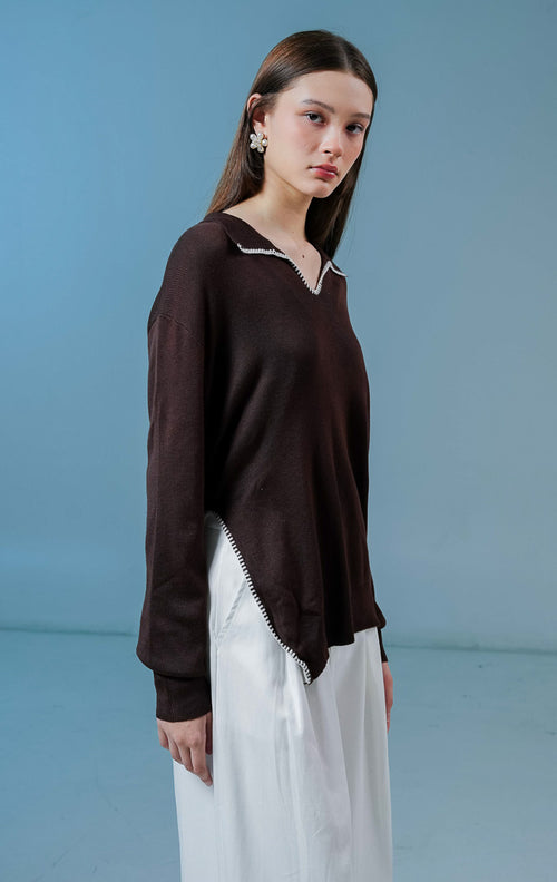 Model wanita mengenakan Maddox V-Neck Contrast Stitch Collared Sweater warna brown, baju sweater rajut wanita lengan panjang warna coklat tua dengan detail jahitan kontras putih di kerah. 