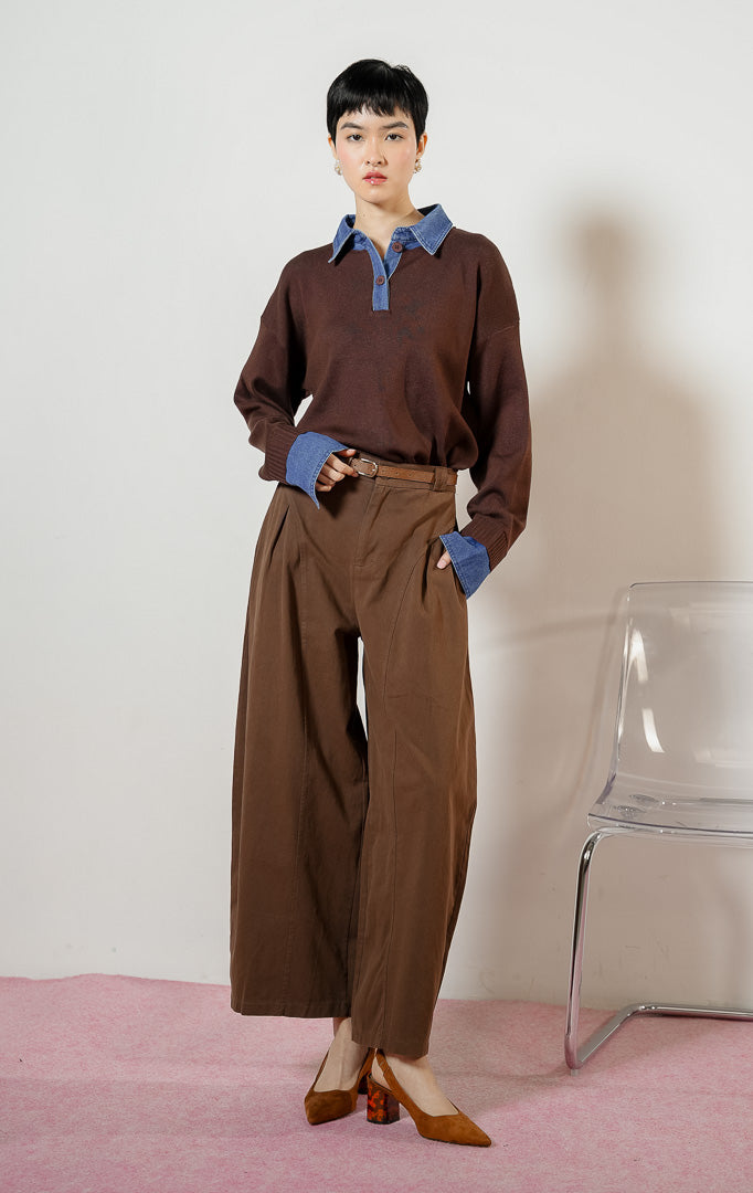 Model wanita berpose duduk mengenakan Susie Denim Collar Cuff Knit Sweater warna dark brown, atasan baju sweater rajut wanita berwarna cokelat tua dengan kerah kemeja dan manset bahan jeans denim biru. 