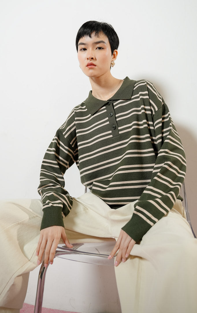Model wanita mengenakan Windsor Stripes Collar Knit Sweater warna dark green, baju sweater rajut wanita lengan panjang model kerah polo motif garis salur hijau tua kombinasi krem. 