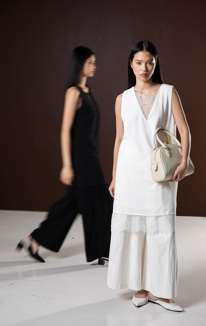 Dress pendek wanita Sydney warna putih bersih tanpa lengan menampilkan kerah V-neck dengan aksen brokat lace transparan di bagian dada dan keliman bawah dress.