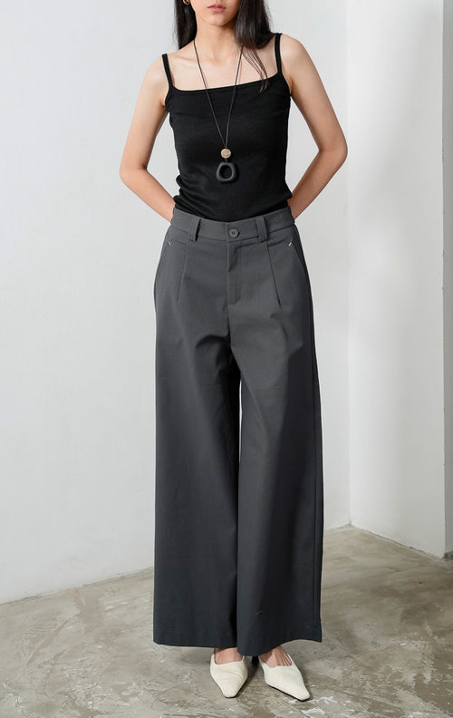 Celana panjang wanita siluet lurus (straight-leg trousers) warna abu-abu tua (dark grey) Sylvie Pants dengan ban pinggang terstruktur berloop ikat pinggang (belt loops), kancing depan, saku miring, dan karet elastis di bagian belakang pinggang (elasticated back waistband). 

