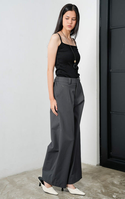 Celana panjang wanita siluet lurus (straight-leg trousers) warna abu-abu tua (dark grey) Sylvie Pants dengan ban pinggang terstruktur berloop ikat pinggang (belt loops), kancing depan, saku miring, dan karet elastis di bagian belakang pinggang (elasticated back waistband). 

