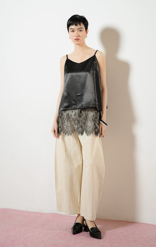 Model wanita mengenakan Juliet Lace Tank Top warna black, atasan camisole tank top satin wanita berwarna hitam dengan detail kelim renda brokat bunga transparan yang anggun. 
