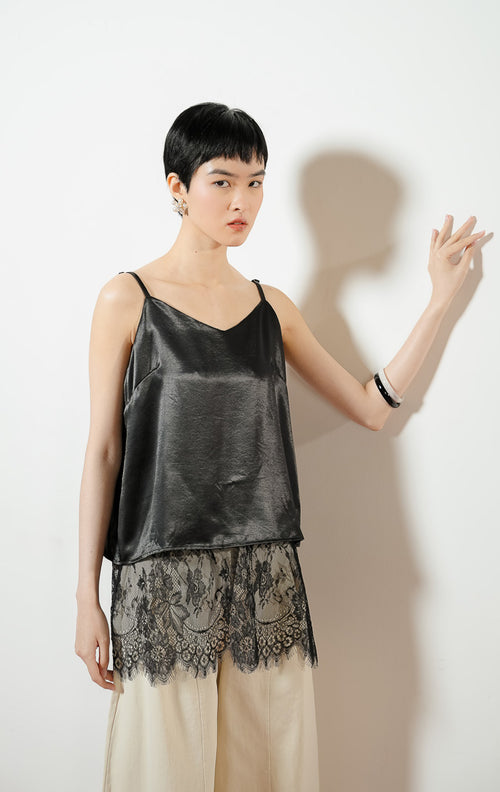 Model wanita mengenakan Juliet Lace Tank Top warna black, atasan camisole tank top satin wanita berwarna hitam dengan detail kelim renda brokat bunga transparan yang anggun. 