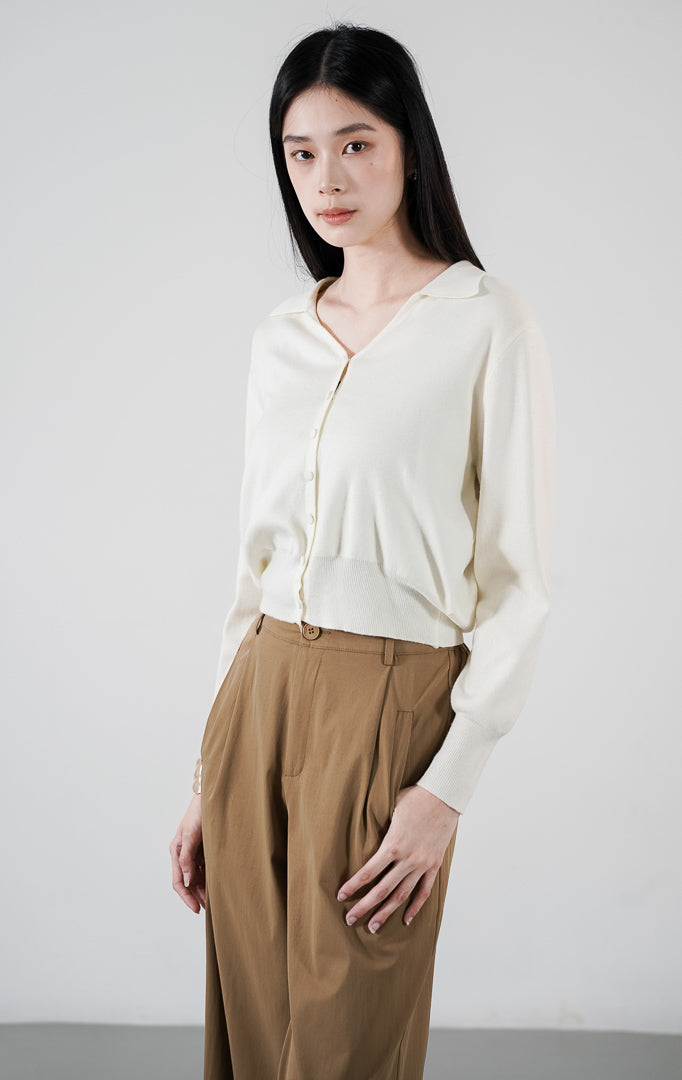 Teja Cardigan warna ivory, kardigan rajut lengan panjang dengan kerah dan kancing bungkus, dipadukan dengan celana khaki
