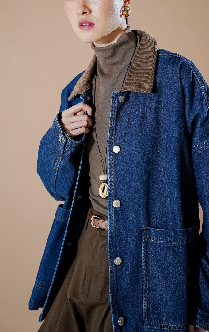 Aleryn Jacket Dark Denim dari This Is April, jaket denim oversized wanita dengan detail kerah korduroi cokelat kontras dan kancing depan.