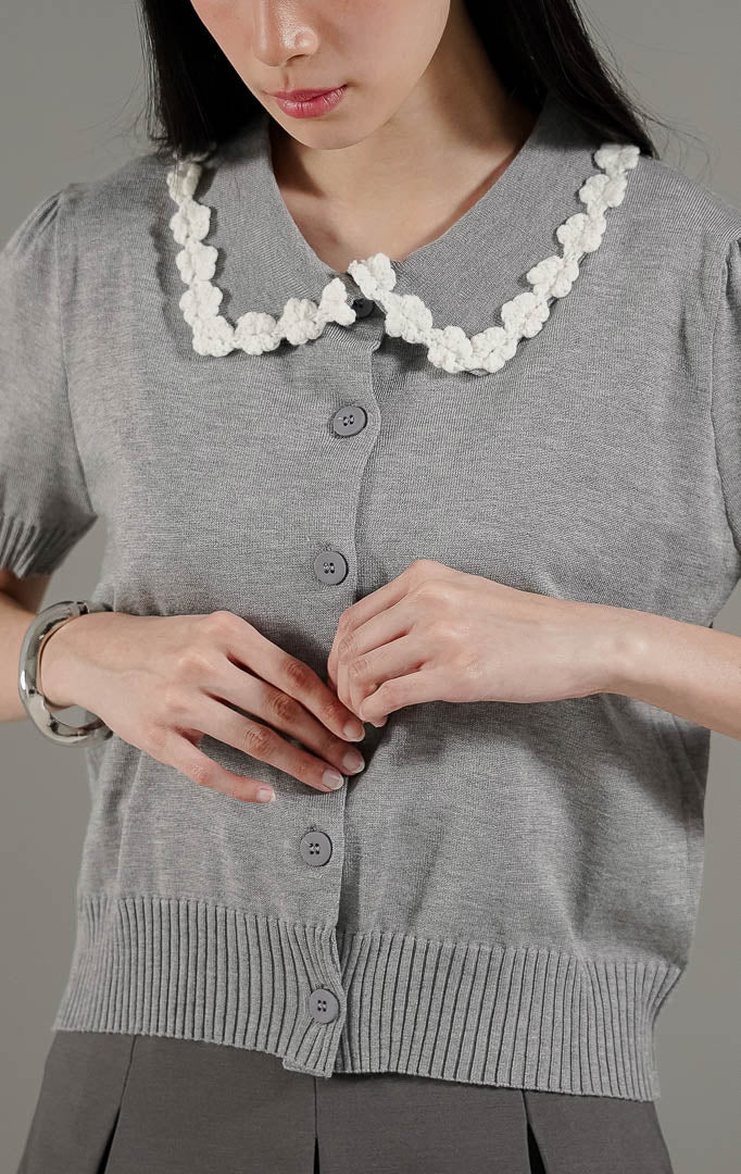 Arielle Cardigan Grey dari This Is April, cardigan rajut lengan pendek warna abu-abu dengan detail kerah bunga timbul 3D warna putih.