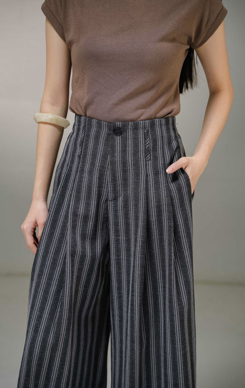 Celana panjang kulot wanita This Is April Ariphron Pants warna hitam abu-abu motif garis-garis putih vertikal pinstripe, dilengkapi detail saku samping dan karet pinggang belakang.