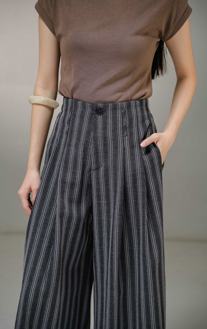 Celana panjang kulot wanita This Is April Ariphron Pants warna hitam abu-abu motif garis-garis putih vertikal pinstripe, dilengkapi detail saku samping dan karet pinggang belakang.