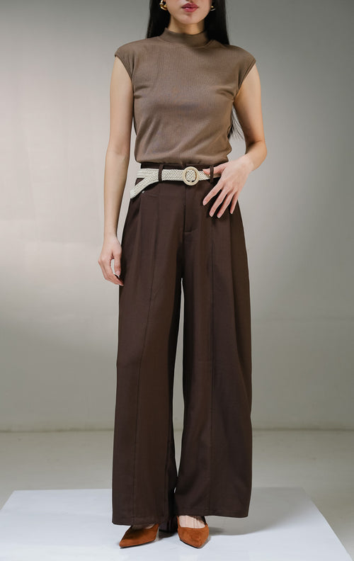 Celana panjang wanita This Is April Arthou Pants warna cokelat tua (dark brown), model celana kain highwaist dengan kancing depan, tempat ikat pinggang, saku samping fungsional, dan karet elastis di bagian belakang. 