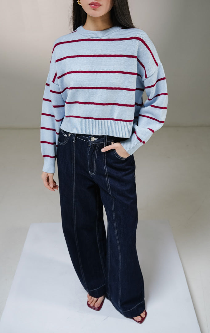 Atasan sweater rajut lengan panjang wanita This Is April Ashbury Sweater warna biru muda dengan motif garis horisontal merah marun dan detail kerah bulat berusuk.