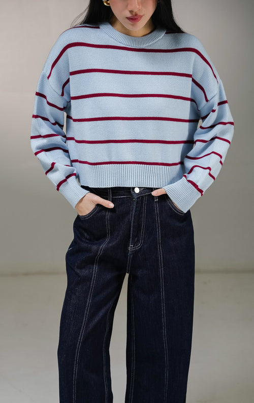Atasan sweater rajut lengan panjang wanita This Is April Ashbury Sweater warna biru muda dengan motif garis horisontal merah marun dan detail kerah bulat berusuk.