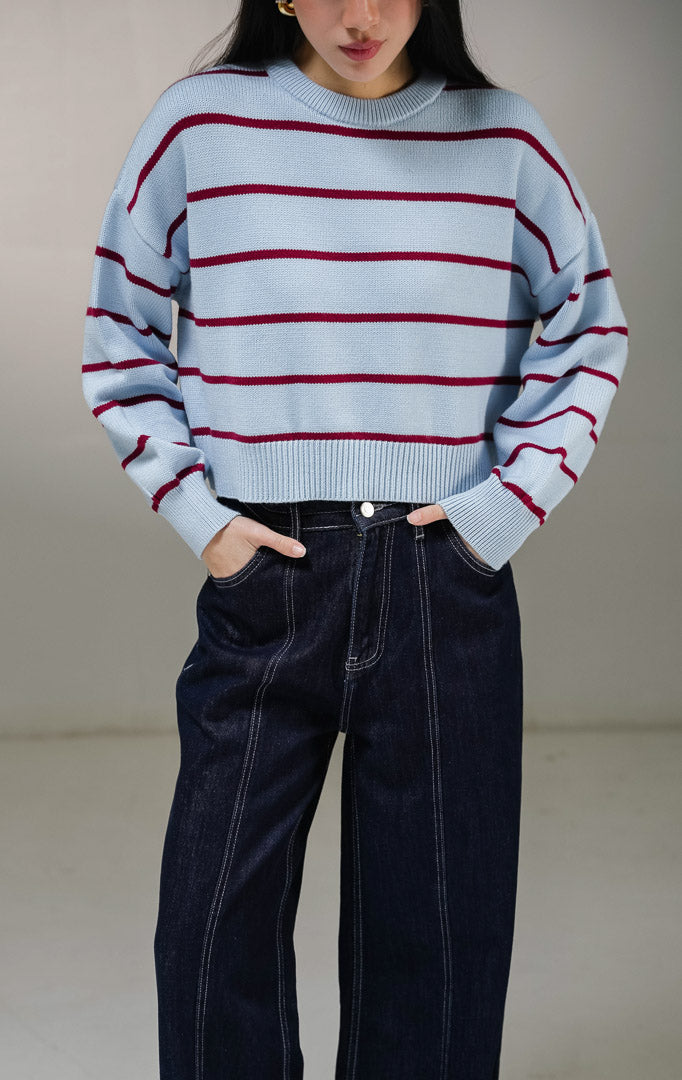 Atasan sweater rajut lengan panjang wanita This Is April Ashbury Sweater warna biru muda dengan motif garis horisontal merah marun dan detail kerah bulat berusuk.