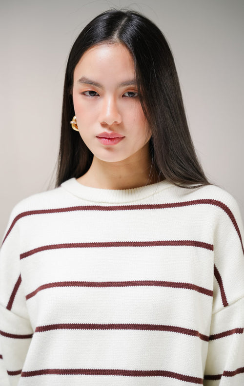 Atasan sweater rajut lengan panjang wanita This Is April Ashbury Sweater warna ivory dengan motif garis horisontal cokelat tua dan detail kerah bulat.