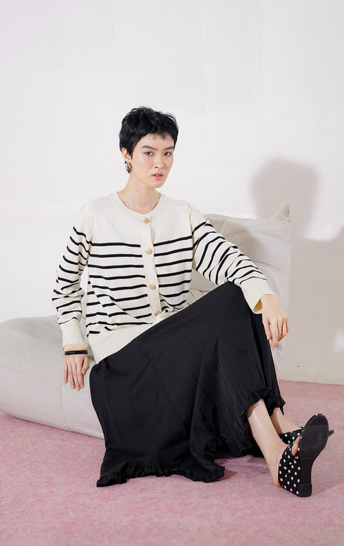 Tampak depan This Is April Aurelie Cardigan warna ivory, cardigan lengan panjang dengan motif garis hitam horizontal, kerah bulat, dan detail kancing depan berwarna emas 